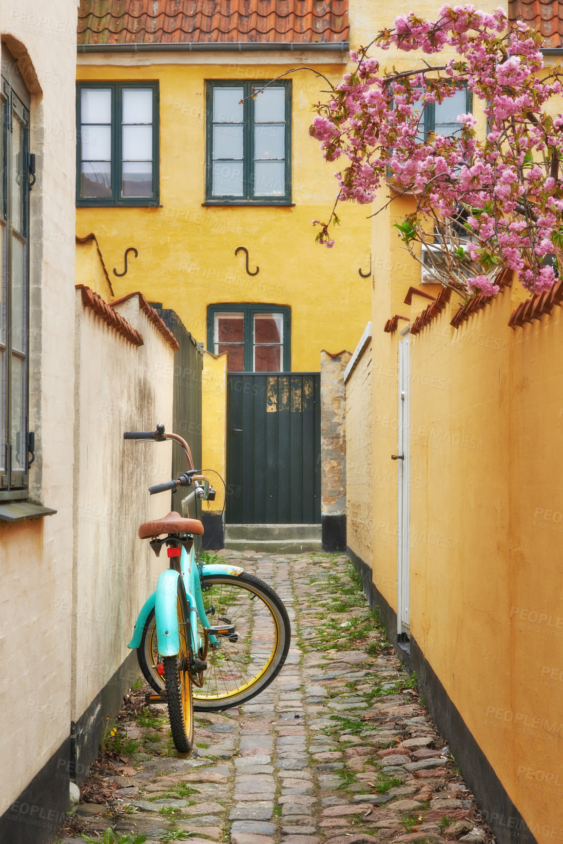 Buy stock photo A bicycle parked in a small alley next to a house in Dragoer, Denmark