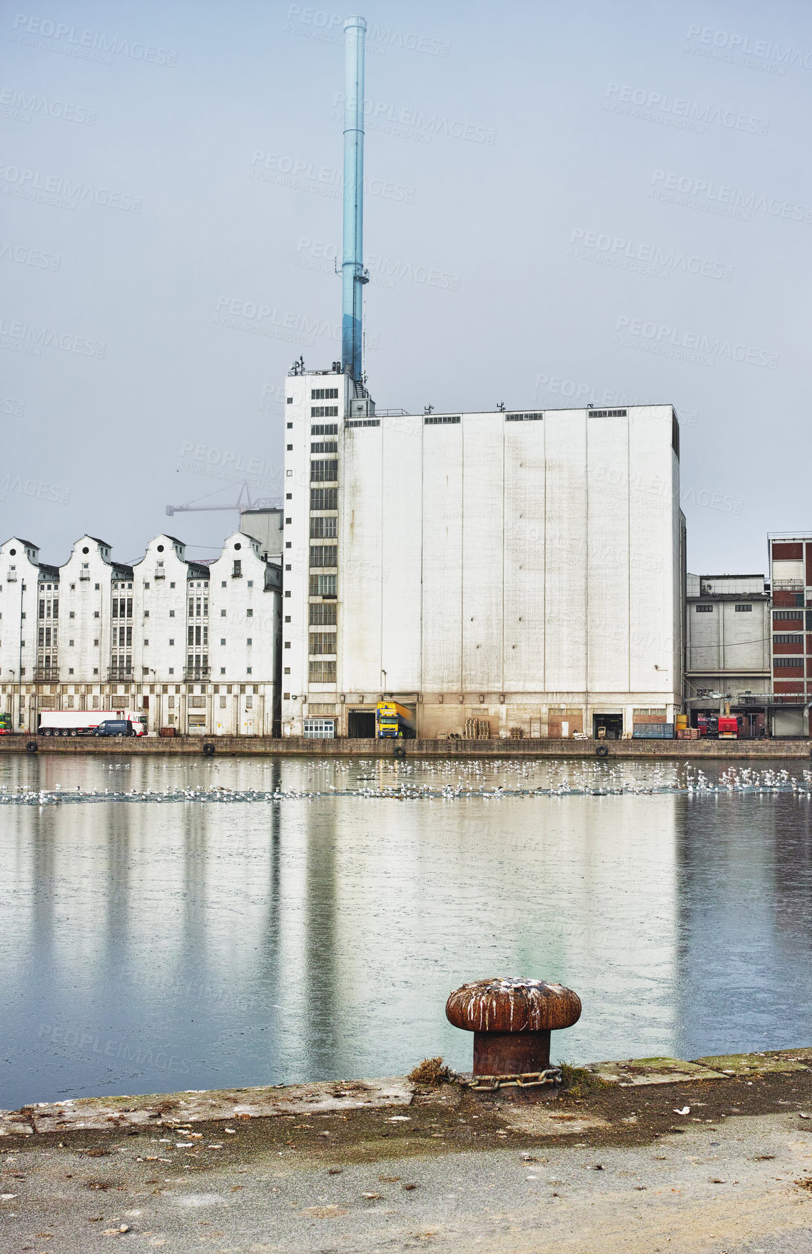 Buy stock photo A factory seen from across a body of water, industrial industry adding to air pollution, contamination and  environmental pollution, deathly toxic for the planet and global state of wellbeing