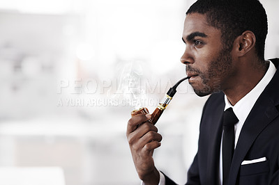 Buy stock photo A young businessman smoking an electronic pipe in an office