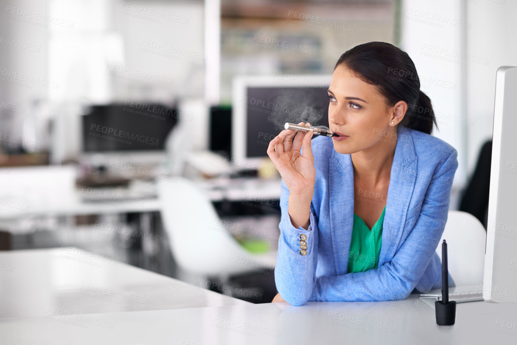 Buy stock photo Shot of a businesswoman smoking and electronic cigarette in an office