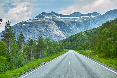 Buy stock photo Mountain, road trip and forest highway with travel, holiday and countryside scenery in Norway. Nature, clouds in sky and street for journey, vacation and outdoor adventure with woods, trees and snow