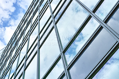 Buy stock photo Low angle, construction and building with glass windows in city for business, office and commercial property with sky. Closeup, architecture and real estate for hotel, accommodation and skyscraper