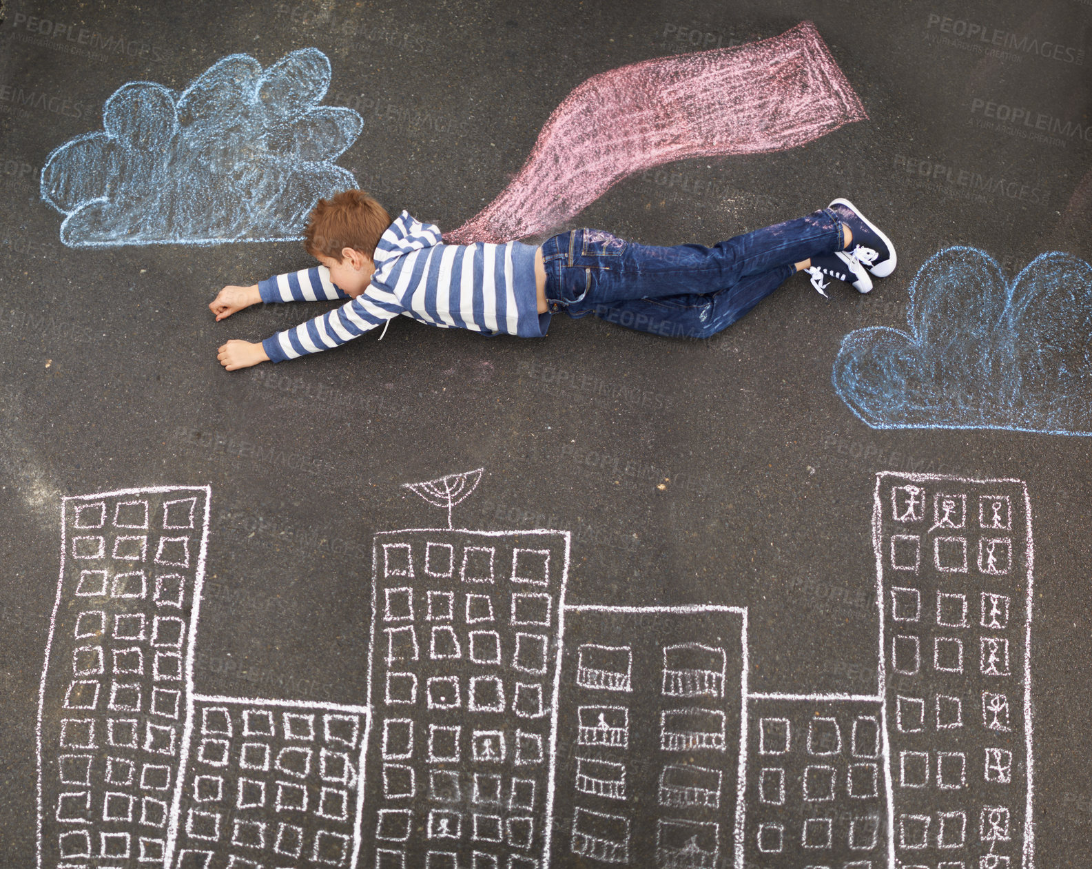 Buy stock photo Top view of a young boy using chalk and imagination to create his own world