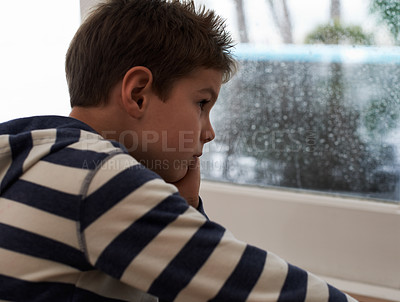 Buy stock photo Window, rain and sad boy child on a floor unhappy, upset or annoyed by bad weather in his home. Glass, depression and kid in a living room frustrated by storm, cold or unexpected winter disaster
