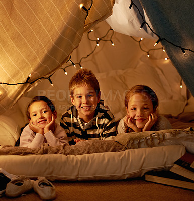 Buy stock photo Kids, happy and playing in blanket fort with portrait for fantasy, bonding and fairy lights at night. Friends, children and face with smile for pajama party, sleepover and pillow tent with lighting 