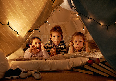 Buy stock photo Children, happy and playing in blanket fort with funny face for fantasy, bonding and string lights at night. Friends, kids and comic gesture for pajama party, sleepover and pillow tent with lighting 