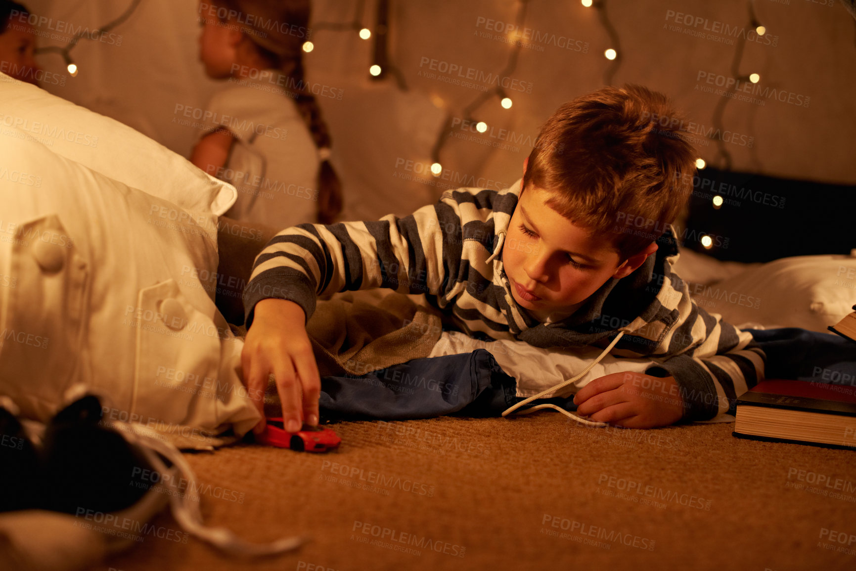 Buy stock photo Toy, car and boy child playing on a floor at night in a house for fun, learning or sibling sleepover. Riding, games and kid with racecar in a living room for driving, fantasy or dream with family