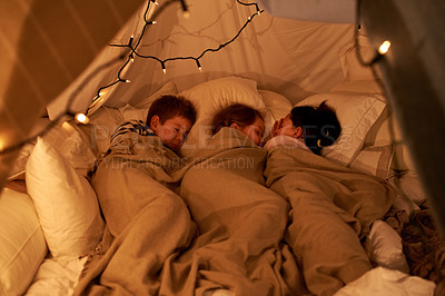 Buy stock photo Shot of three young children sleeping in blanket tent