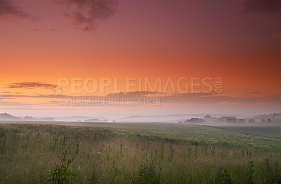 Buy stock photo Sunset, fog or field of grass in countryside, pasture or scenery for landscape, banner or wallpaper. Mist, dramatic sky or sunlight for mystical, rural or panorama of peaceful grassland screen saver
