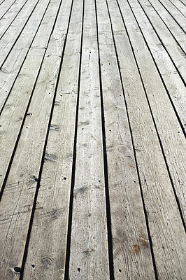 Buy stock photo Closeup of a wooden plank surface. Light grey vintage flooring with slats forming an outdoor terrace. Old textures of hard wood floor used as a walkway or deck. Long vertical outdoor floorboards