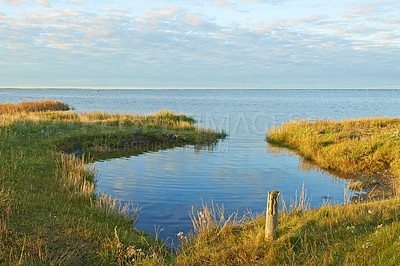Buy stock photo Lake, field and landscape with sky in horizon, grass and environment with sunshine in Jutland. Water, sea or dam with clouds, sustainability and ecology for earth in summer at countryside in Denmark
