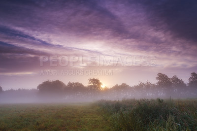 Buy stock photo A misty morning sunrise over a picturesque farm landscape