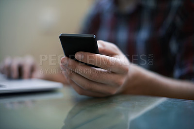 Buy stock photo Cropped shot of a man using a laptop and a cellphone
