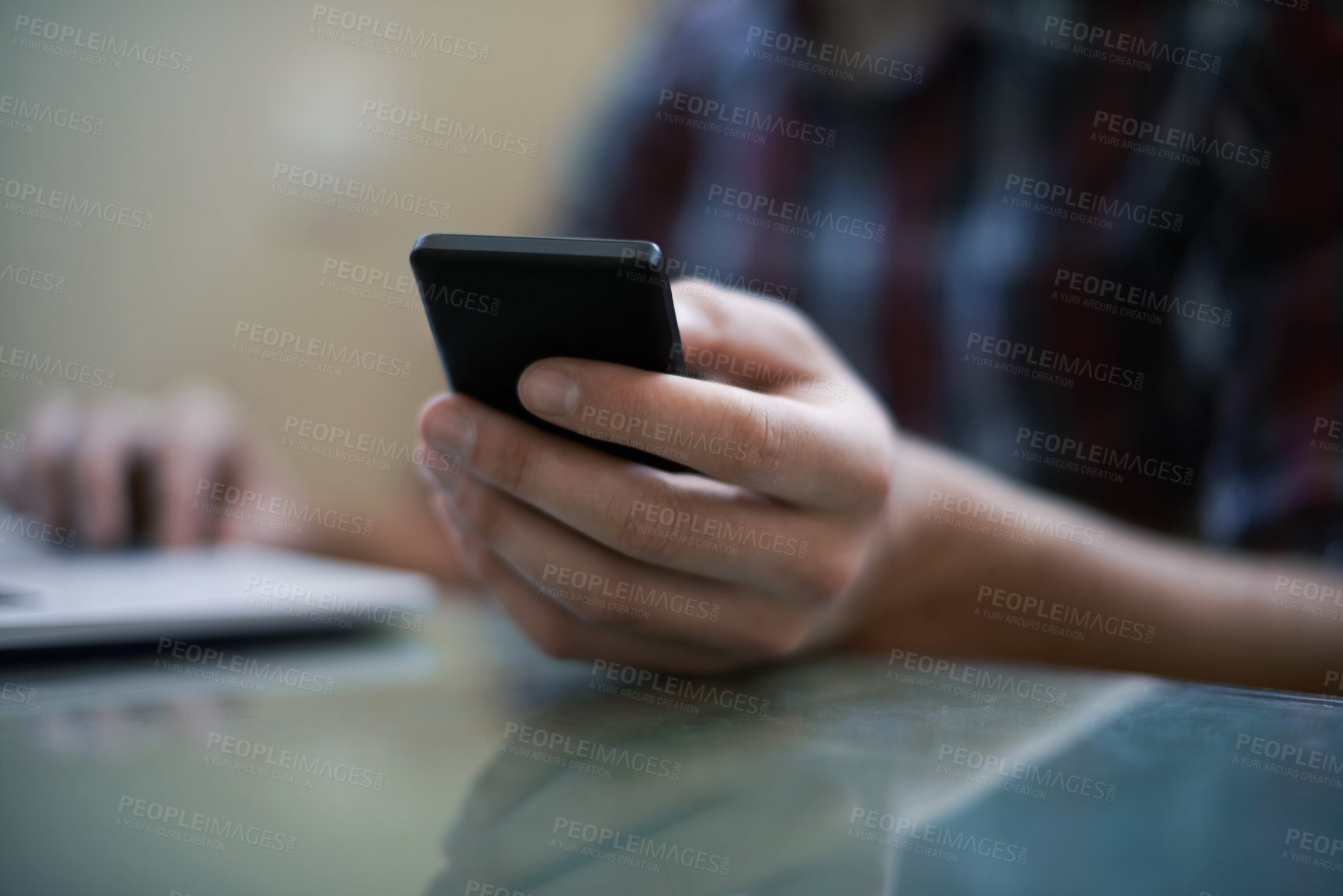 Buy stock photo Cropped shot of a man using a laptop and a cellphone
