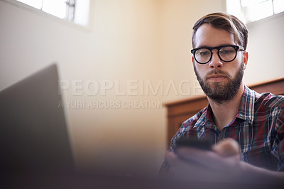 Buy stock photo Man, laptop and phone for planning, freelancer and typing or check email for communication. Male person, remote work and notification in home office, research and browse on internet or app and web