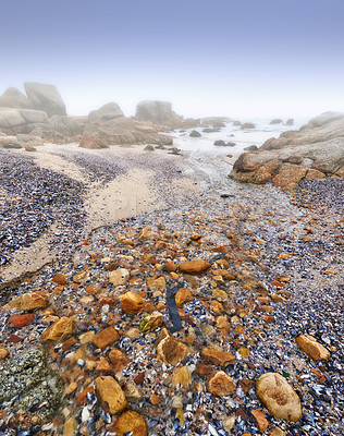 Buy stock photo Beach, rocks and stone on sand in nature, landscape or environment with fog on sea or horizon. Offshore, ocean and travel on vacation or holiday to South Africa in summer to calm water or waves