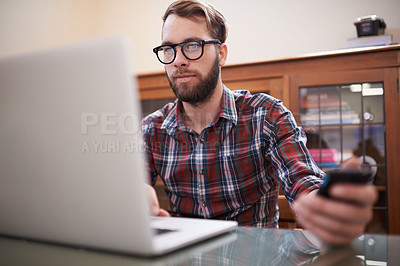 Buy stock photo Man, laptop and phone for planning, eyewear and typing or check email for communication. Male person, remote work and notification in home office, reflection and freelancer on internet or app and web
