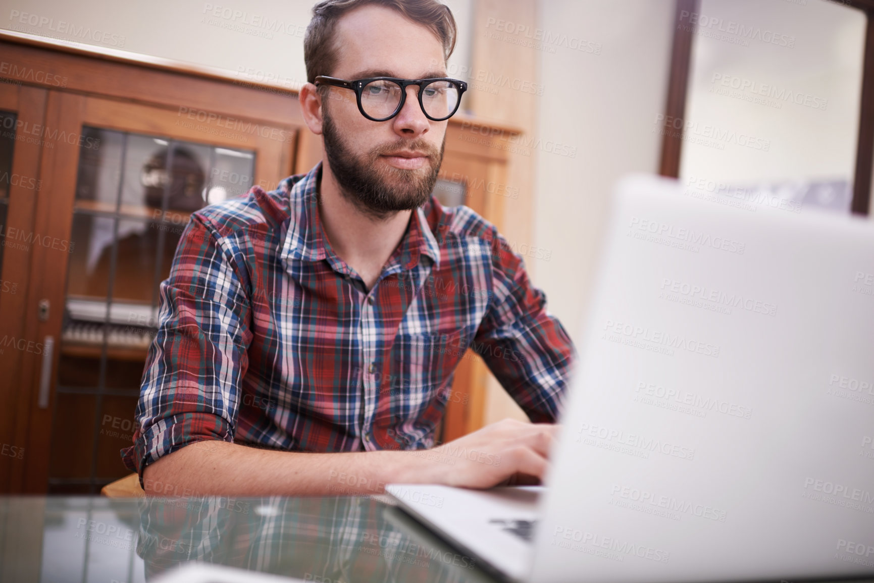 Buy stock photo Shot of a handsome young hipster working on a laptop
