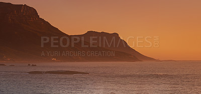 Buy stock photo Sea, sunset and mountain on island, paradise and tourist destination for summer vacation in nature. Rocks, ocean and color in sky in cape town, peace and outdoor travel of sustainable environment