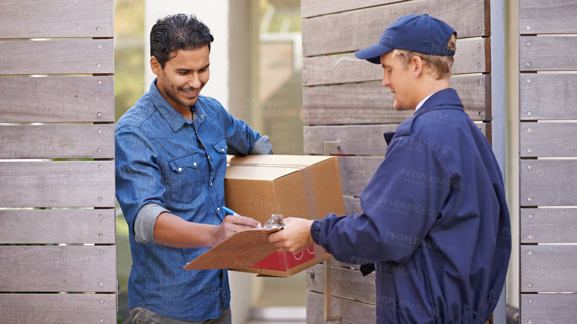 Buy stock photo A friendly delivery man delivering a package to a home