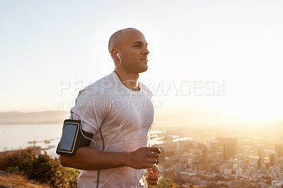 Buy stock photo Man, running and sunset with earphones on mountain for workout, exercise or cardio training. Active male person or runner listening to music, podcast or audio for motivation in health and wellness