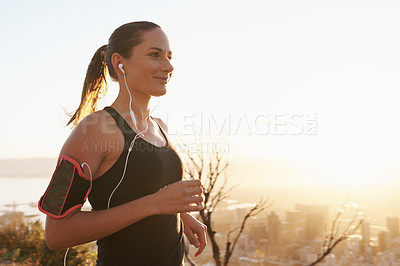 Buy stock photo Woman, running and sunset with earphones on mountain for workout, exercise or cardio training. Active female person or runner listening to music, podcast or audio for motivation, health and wellness