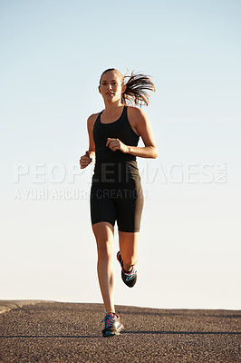 Buy stock photo Woman, running in street and exercise for cardio, health and fresh air when training for marathon with sky background. Sports, exercise and athlete in city for workout, wellness and endurance outdoor