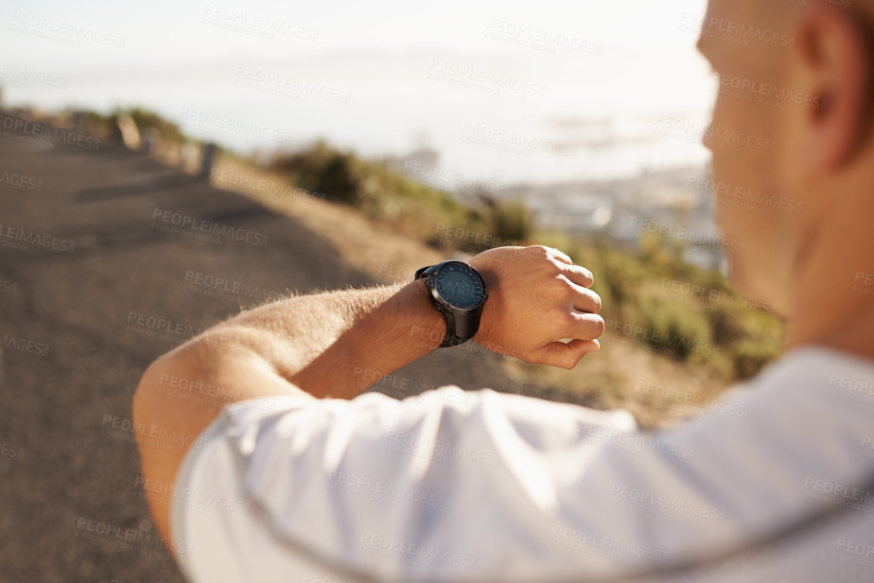 Buy stock photo Cropped image of a male runner looking at his watch before a run