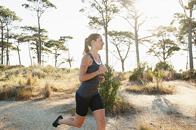 Buy stock photo Fitness, running and woman on road in trees for health, wellness and strong body development. Workout, exercise and girl runner on path in nature for marathon training, performance and challenge.