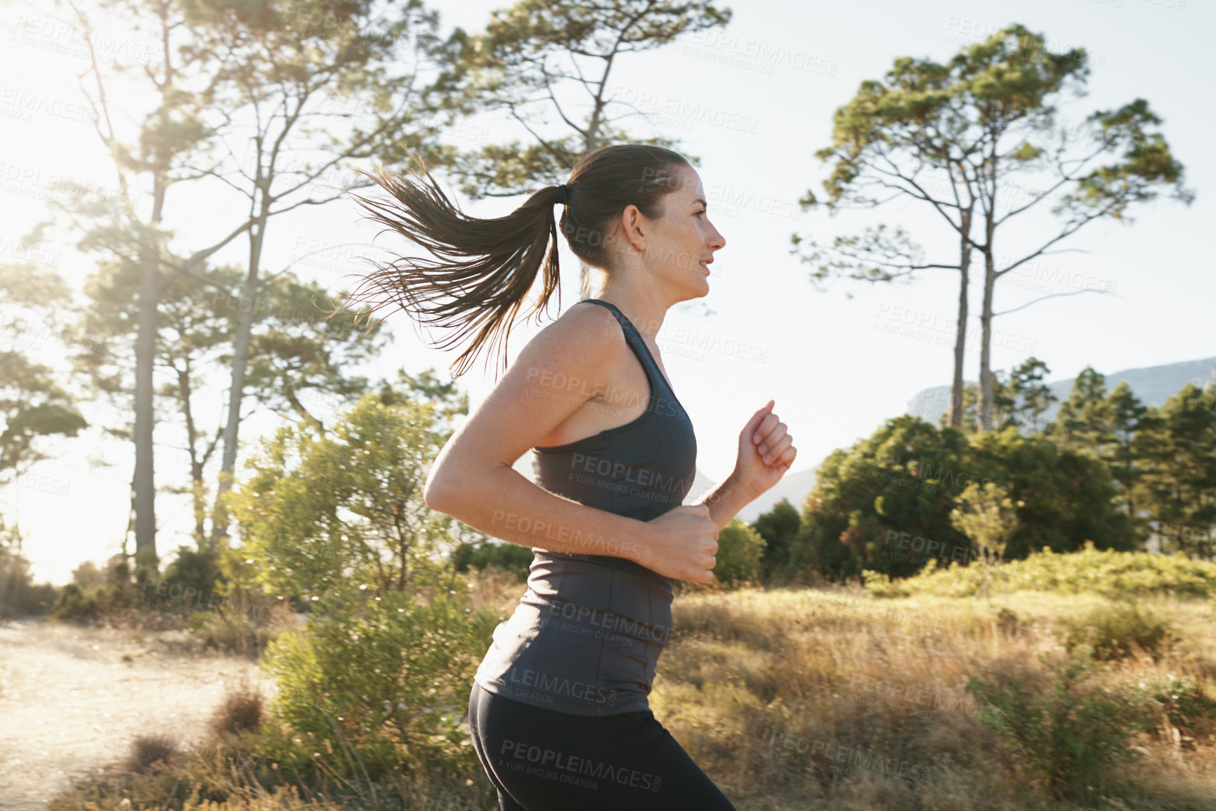 Buy stock photo Exercise, running and woman on path in mountain for health, wellness and strong body development. Workout, fitness and girl runner on road in nature for marathon training, performance and challenge.