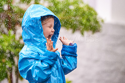 Buy stock photo Young girl, rain and playing outside in winter, raincoat and playful in the water. Joyful, laughing and happy child in cold weather and raindrops, screaming toddler and excited in backyard of home