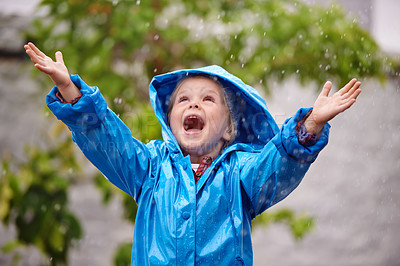 Buy stock photo Shot of a young girl playing outside in the rain
