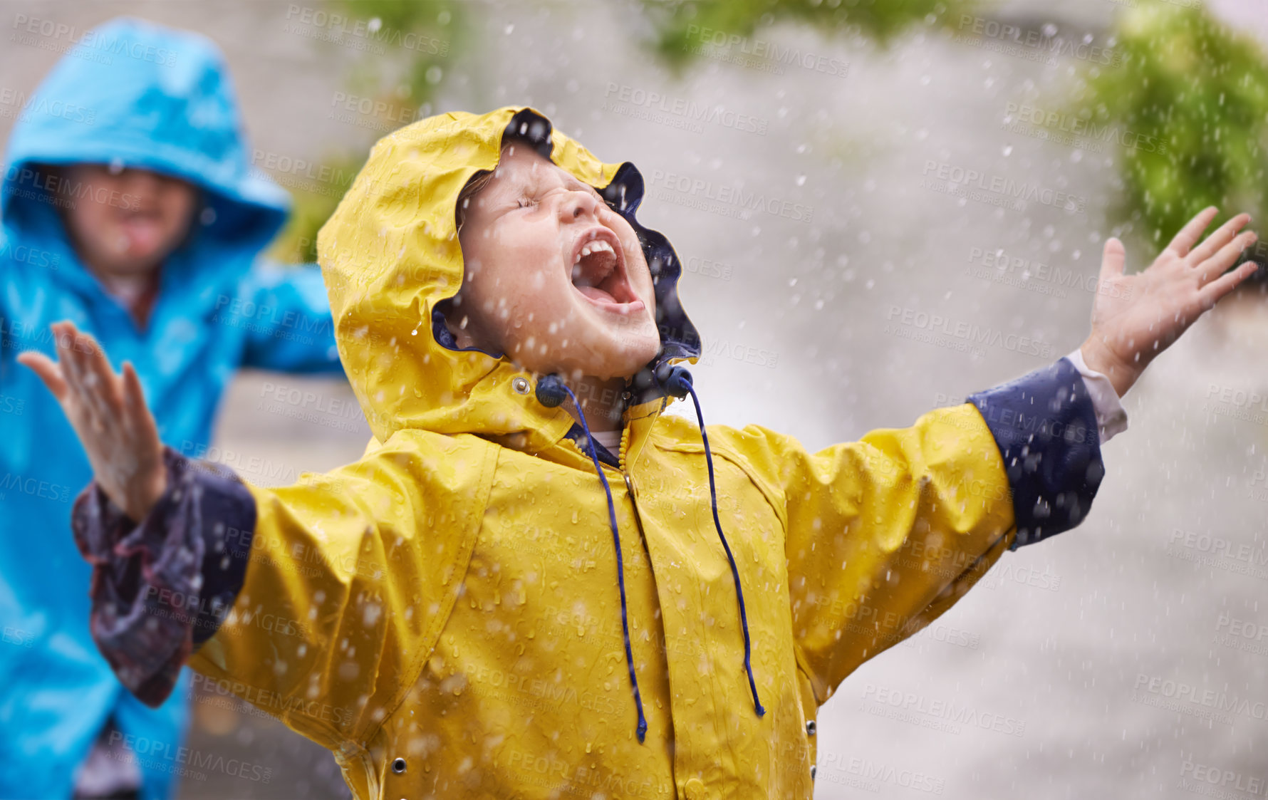 Buy stock photo Shot of a young brother and sister playing in the rain