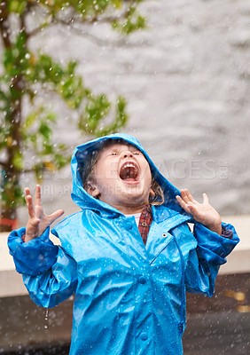 Buy stock photo Wet weather, raincoat and a girl playing in the rain outdoor alone, having fun during the cold season. Kids, winter or freedom with an adorable little female child standing arms outstretched outside