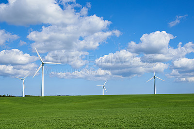 Buy stock photo Clouds, grass and wind turbine for energy, electricity and sustainability in countryside, field and landscape. Blue sky, pasture and windmill for power outdoor in environment, nature and meadow 
