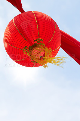 Buy stock photo Below view of a red lantern hanging against a background of sky copyspace. Round lantern decorating the street for a fun festival with copy space, celebrating wealth, prosperity, and a thriving life