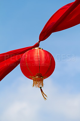 Buy stock photo Red Chinese lantern in the air decorating the streets of China. Traditional Asian decor for new year celebrations in beautiful sky background. Creative cultural art hanging high up on a summer day