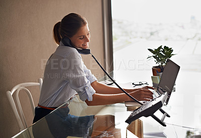 Buy stock photo Businesswoman, laptop and talking on phone professional, formal clothes and working in office. Female person, smile and communicate with clients or consultant, communication and typing in computer