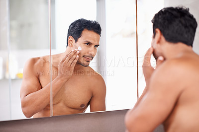 Buy stock photo Man, mirror and cream in bathroom for skincare, cosmetic treatment and hygiene in reflection for routine. Topless, handsome person with smile and touch face for groom, wellness product and fresh  