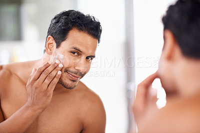 Buy stock photo Skincare, mirror and cream with man in bathroom for morning routine, facial treatment and cosmetics. Self care, confidence and face of male person for sunscreen, lotion or moisturizer in reflection.