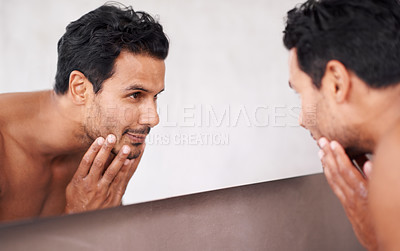 Buy stock photo Cropped shot of a handsome young man taking care of his skin