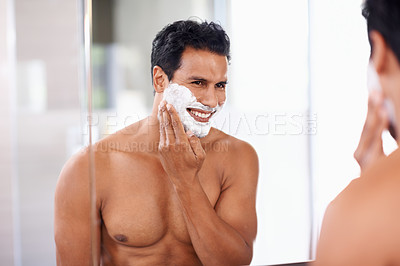 Buy stock photo Man, skincare and foam on face in bathroom mirror for shaving, grooming and hair removal. Smile, cosmetics and happy male person for wellness, facial treatment or morning routine with reflection.