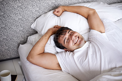Buy stock photo Man, sleep and bed for stretch, wellness and happy for rest in pajamas and bedroom for home and joyful. Male person, relax and dreaming at house, calm and tired in sleepwear and taking nap and smile