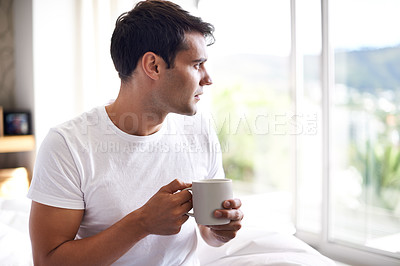 Buy stock photo Man, coffee and bed with window for morning, wakeup, daydream or thinking with sunlight and caffeine. Young and male person with looking and relax for ponder, thought idea indoor for weekend   