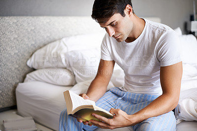 Buy stock photo Man, reading and pajamas for morning, routine and book in bedroom for wellness and literature for class. Male person, hobby and student for relaxation, leisure and novel for home free time in house