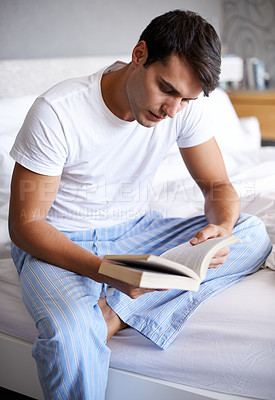 Buy stock photo Man, reading and pajamas for book, routine and morning in bedroom for wellness and literature for class. Male person, hobby and student for relaxation, leisure and novel for home free time in house