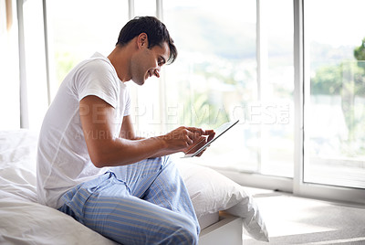 Buy stock photo Man, happy and tablet in social media, bed and entertainment in pajamas and morning routine. Male person, browse and bedroom with technology, scroll and smile in sleepwear at home for relaxation