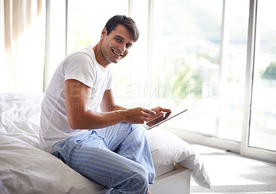 Buy stock photo Portrait, man and bed with tablet for communication, internet and technology in bedroom, home and apartment in morning time. Male person, student and digital pad on social media, browsing and online