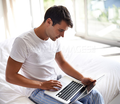Buy stock photo Man, bed and laptop for communication, internet and technology in bedroom, home and apartment in morning time. Male person, student and computer on social media, browsing and online connectivity