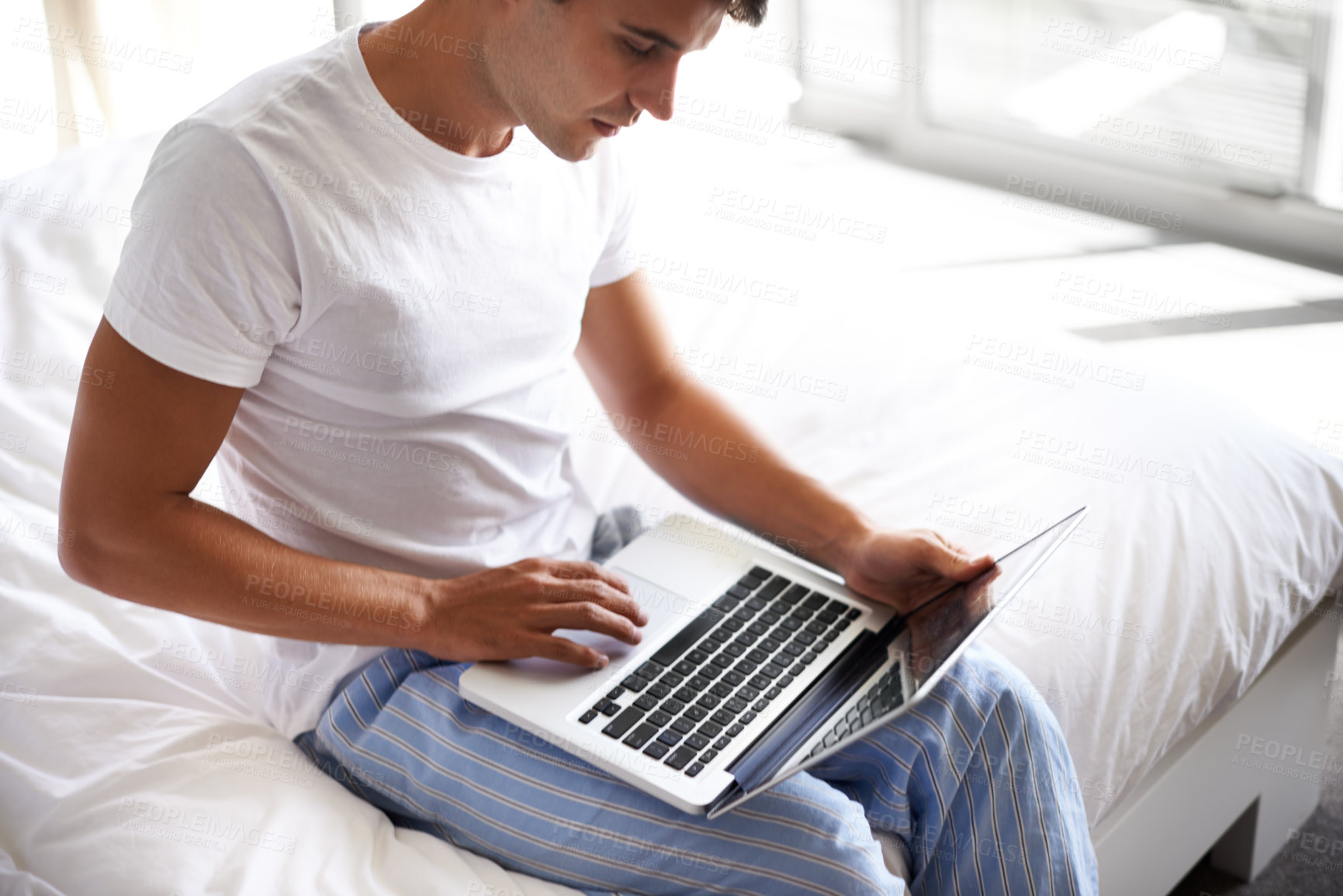 Buy stock photo Man, happy and laptop in bedroom, scroll and entertainment in pajamas and morning routine. Male person, browse and social media with technology, bed and smile in sleepwear at home for relaxation